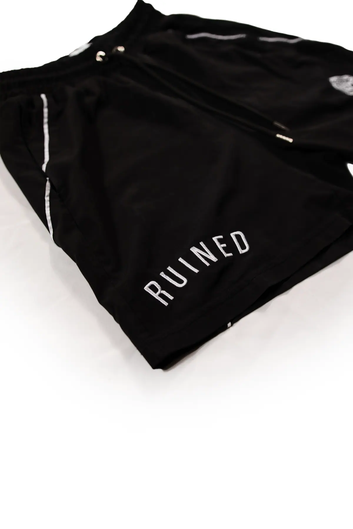 RUINED wordmark stitched along the short leg